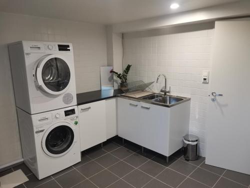 a kitchen with a washing machine and a sink at Vila Ösmo in Ösmo