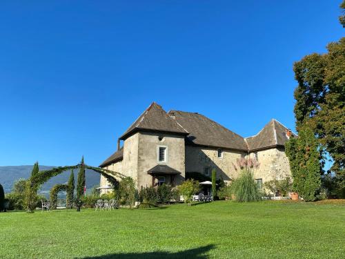 a large stone house on a field of grass at Château de Morgenex in Vallières