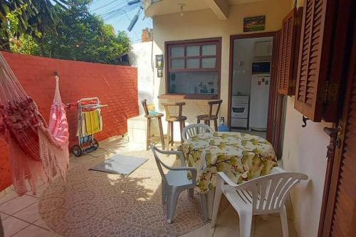 een patio met een tafel en stoelen en een keuken bij Espaço inteiro: casa Manguinhos/Geribá in Búzios