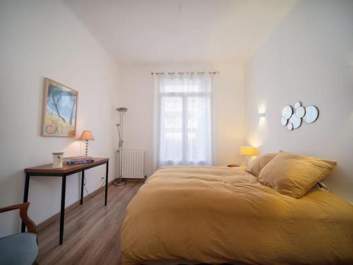 een slaapkamer met een bed, een bureau en een raam bij Appartement tout équipé avec terrasse au cœur de Marseille in Marseille