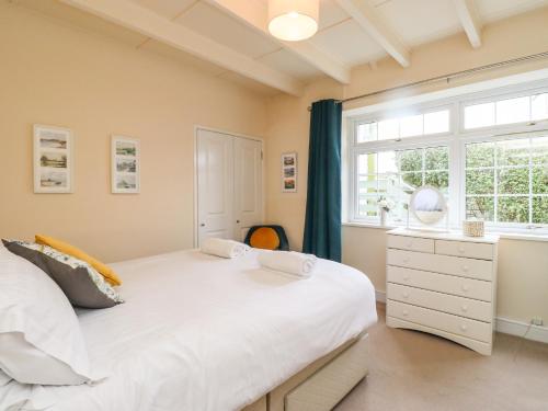 a bedroom with a large white bed and a window at Sunshine Cottage in Seahouses
