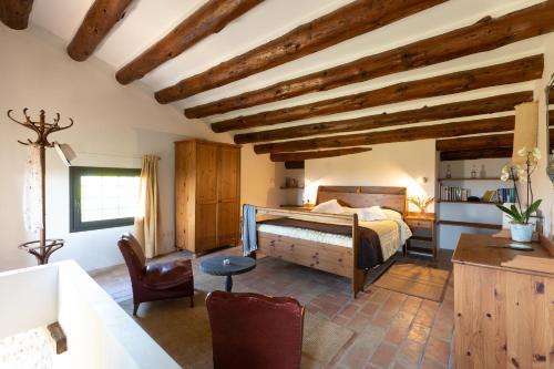 Un dormitorio con una cama en una habitación con techos de madera. en B&B Mas Coquells Rural - Habitació Colmena, en Vilanant
