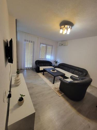 a living room with a couch and a table at Sunny Hill Apartment in Prishtinë