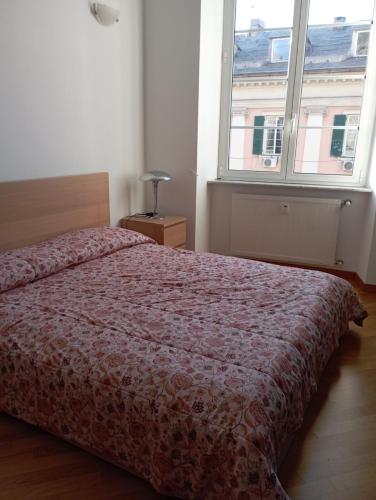 um quarto com uma cama e uma grande janela em Raibetta Apartment em Gênova