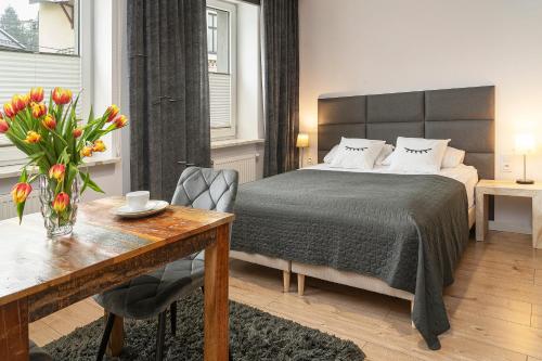sypialnia z łóżkiem i stołem z wazonem kwiatów w obiekcie Podskale Street 2 w Krakowie