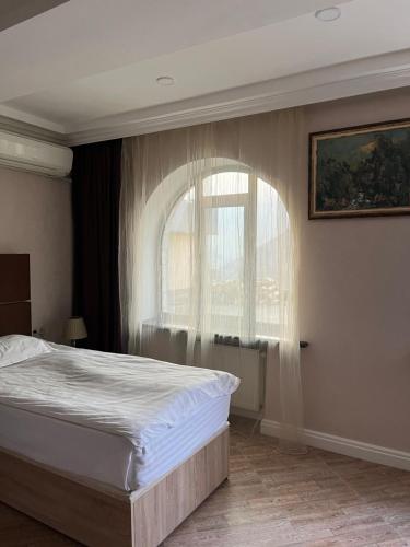 a bedroom with a bed and a window at Grand House Hotel & Zipline Kapan, Armenia in Kapan