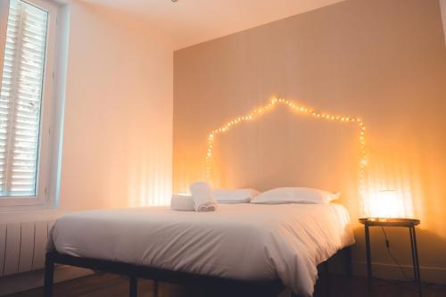 - une chambre dotée d'un lit avec des lumières sur le mur dans l'établissement L’Arbois – T2 pour 4 personnes, à Tours