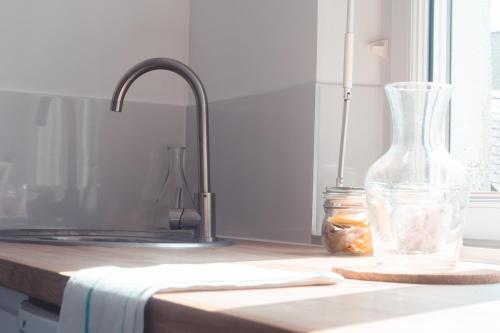 un vase en verre assis sur un comptoir à côté d'un évier dans l'établissement L’Arbois – T2 pour 4 personnes, à Tours