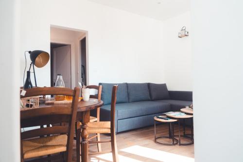 un salon avec un canapé bleu et une table dans l'établissement L’Arbois – T2 pour 4 personnes, à Tours