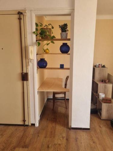 un couloir avec une table et des vases sur une étagère dans l'établissement Appartement Rooftop / Terrasse, à Marseille