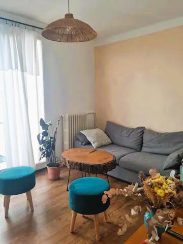 un salon avec un canapé bleu et une table dans l'établissement Appartement Rooftop / Terrasse, à Marseille