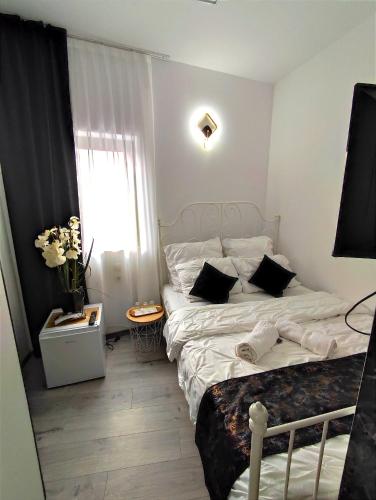 a small bedroom with a bed and a window at Regal Guest House in Sighetu Marmaţiei