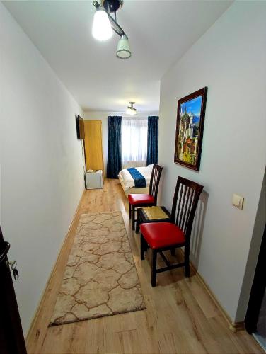 a living room with two chairs and a bed at Regal Guest House in Sighetu Marmaţiei