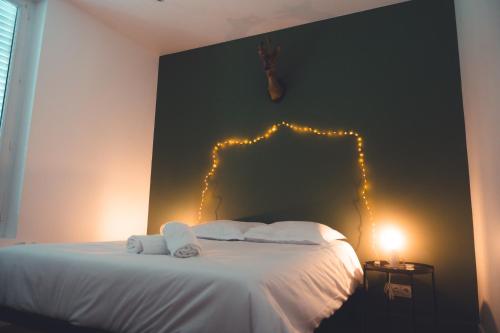 een slaapkamer met een bed met verlichting aan de muur bij Le Chenin T2 pour 4 personnes in Tours
