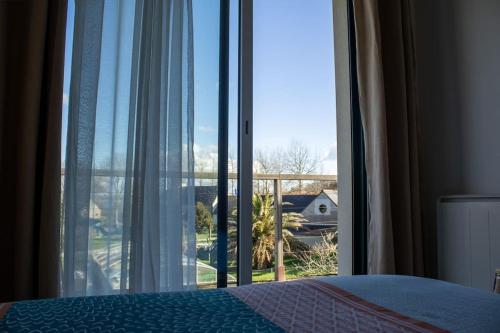 a bedroom with a bed and a large glass window at Ti Ar Park/ Wifi /Grands espaces in Roscanvel