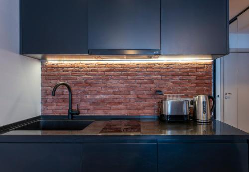 a kitchen with a sink and a brick wall at Gudauri Mountain Views in Gudauri