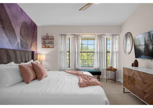 a bedroom with a large white bed and windows at Luxury Model Townhome - 5 minutes from Disney in Orlando
