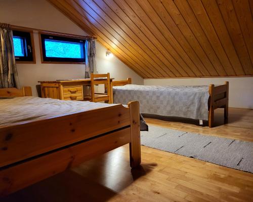 a bedroom with two beds and a wooden ceiling at Mäntymajat in Äkäslompolo