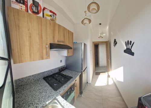 a kitchen with a stove and a refrigerator at Zenata ocean park appartement in Mohammedia