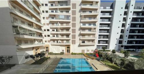 a large apartment building with a swimming pool in front of it at Zenata ocean park appartement in Mohammedia