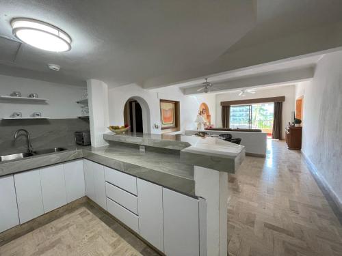a large kitchen with white cabinets and a counter top at Amazing Ocean View in Puerto Vallarta