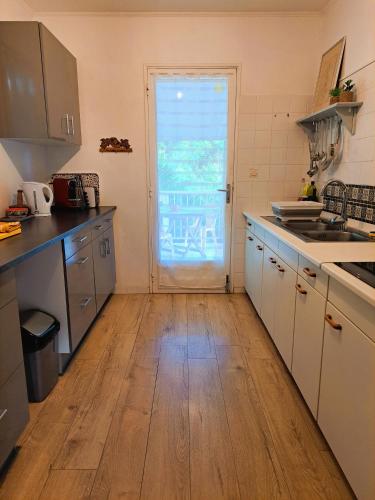 a kitchen with a wooden floor and a door at Ti Caz Marley - Bassin Manapany-Les-Bains in Saint-Joseph