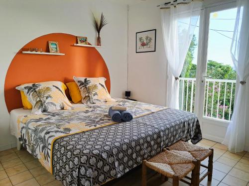 ein Schlafzimmer mit einem großen Bett mit einem orangefarbenen Kopfteil in der Unterkunft Ti Caz Marley - Bassin Manapany-Les-Bains in Saint-Joseph