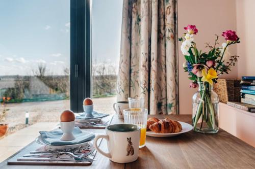 a table with breakfast foods and a window with a view at The Linhay in Peterborough