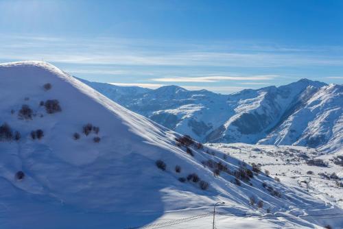 a snow covered mountain with mountains in the distance at Gudauri Mountain Views in Gudauri