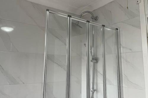 a shower with a glass door in a bathroom at M6 Jct 10, 2 Bed House Wolverhampton-Walsall in Willenhall