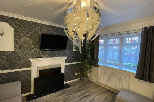 a living room with a chandelier and a fireplace at M6 Jct 10, 2 Bed House Wolverhampton-Walsall in Willenhall