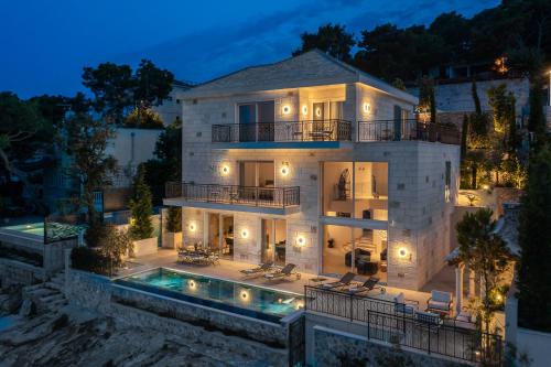 a large house with a swimming pool at night at Villa Stara in Selca