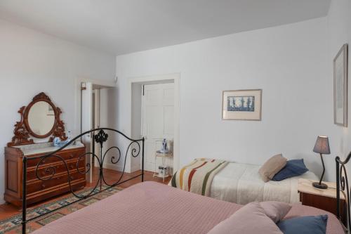 a bedroom with two beds and a mirror on the wall at Casa do Terreiro by An Island Apart in São Vicente
