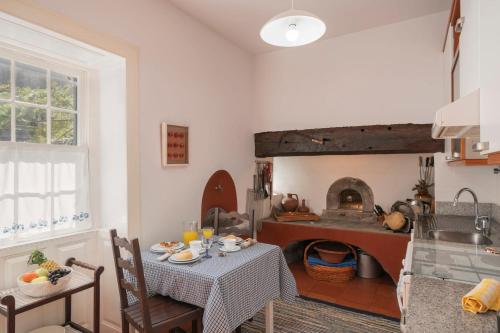 a kitchen with a table and a kitchen with a fireplace at Casa do Terreiro by An Island Apart in São Vicente