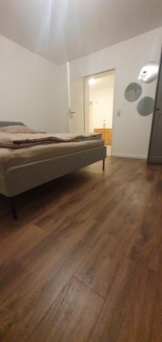 a bedroom with a bed and a wooden floor at Stube 21 in Weingarten