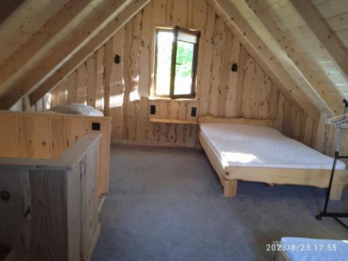 a bedroom in a log cabin with a bed and a window at Jędrzejówka in Kazimierz Dolny