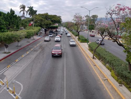 a street with cars driving down a road with trees at Habitación privada entrada independiente in Tuxtla Gutiérrez