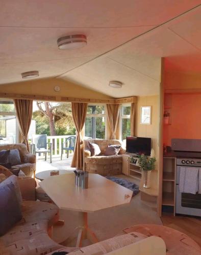 a living room with a couch and a table at Sandy Toes Hoburne Devon Bay Holiday Park. in Paignton