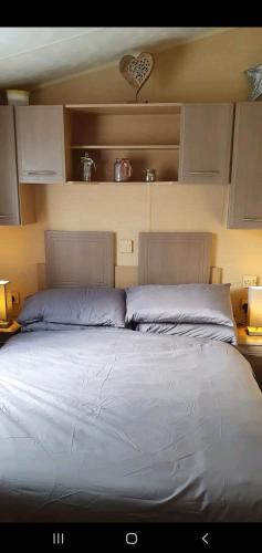 a bedroom with a large bed with two pillows at Sandy Toes Hoburne Devon Bay Holiday Park. in Paignton