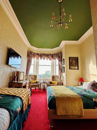 a hotel room with two beds and a chandelier at Rosehall Hotel in Edinburgh