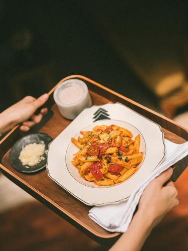 a tray with a plate of pasta on a table at Fausto by Andean in Lima