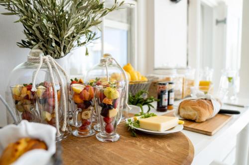 a table with a vase filled with fruit and cheese at Southern Cross Beach House in Plettenberg Bay