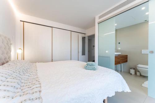 1 dormitorio con 1 cama blanca grande y baño en Luxury flat with sea view in Costa del Sol, en Fuengirola