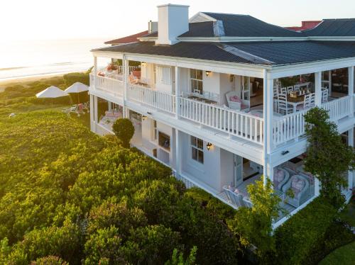 una vista aérea de una casa blanca con el océano en el fondo en Southern Cross Beach House, en Plettenberg Bay