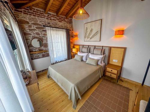 a bedroom with a bed and a brick wall at Cundalis1893 in Ayvalık