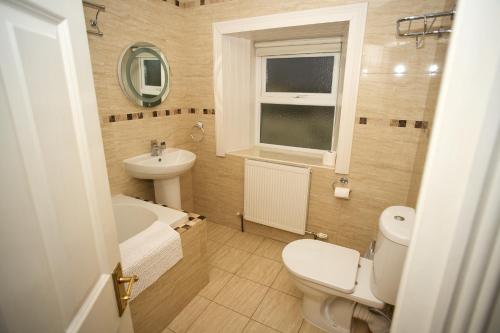 a small bathroom with a toilet and a sink at Five Glens Inn in Manorhamilton