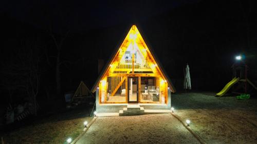 a small house with lights on it at night at Cabana AFrame Olanesti in Băile Olăneşti