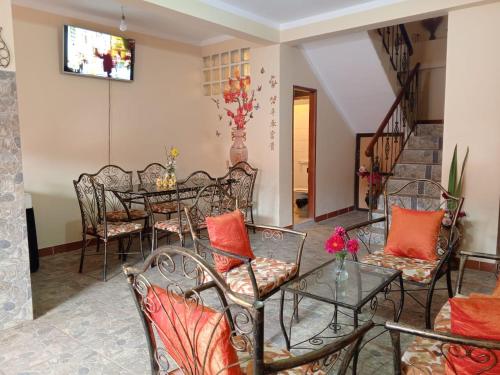 a dining room with a table and chairs with orange pillows at Villa Bella Copacabana in Copacabana