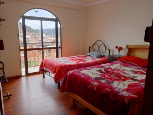 two beds in a room with a large window at Villa Bella Copacabana in Copacabana