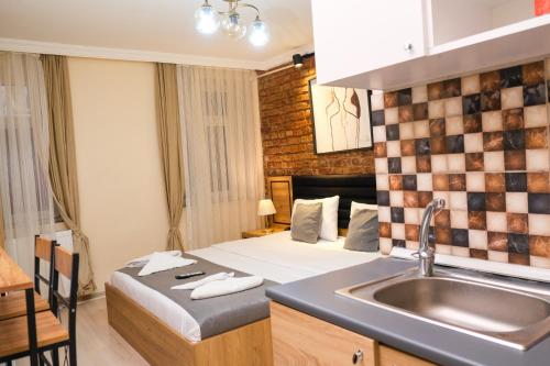 ein Zimmer mit einem Bett mit Waschbecken und einer Küche in der Unterkunft Taksim Nikea Suites 80 in Istanbul